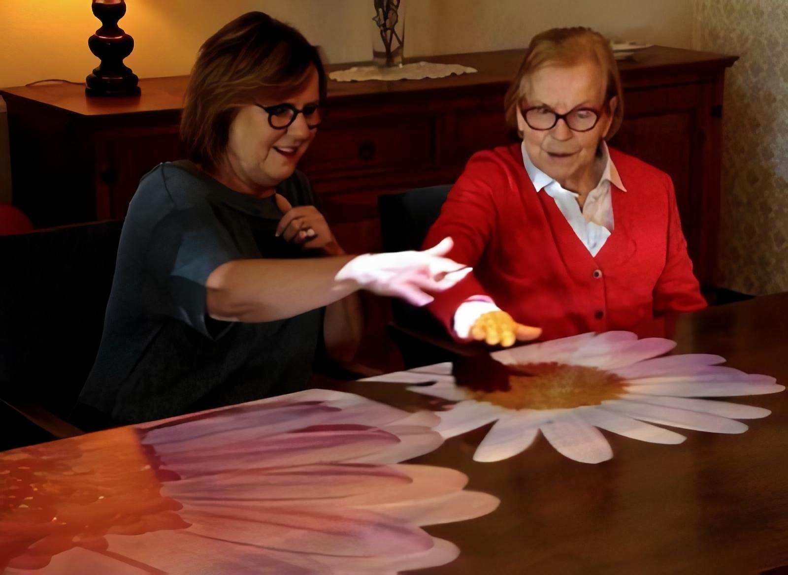 Foto van Rita Tummers met haar moeder die spelen op de Tovertafel